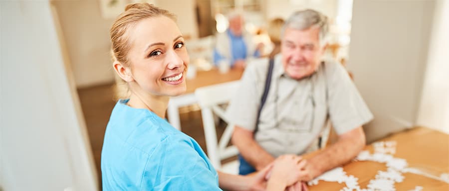 Pflegekraft mit Patient – Digitale Sichtbarkeit schafft Vertrauen