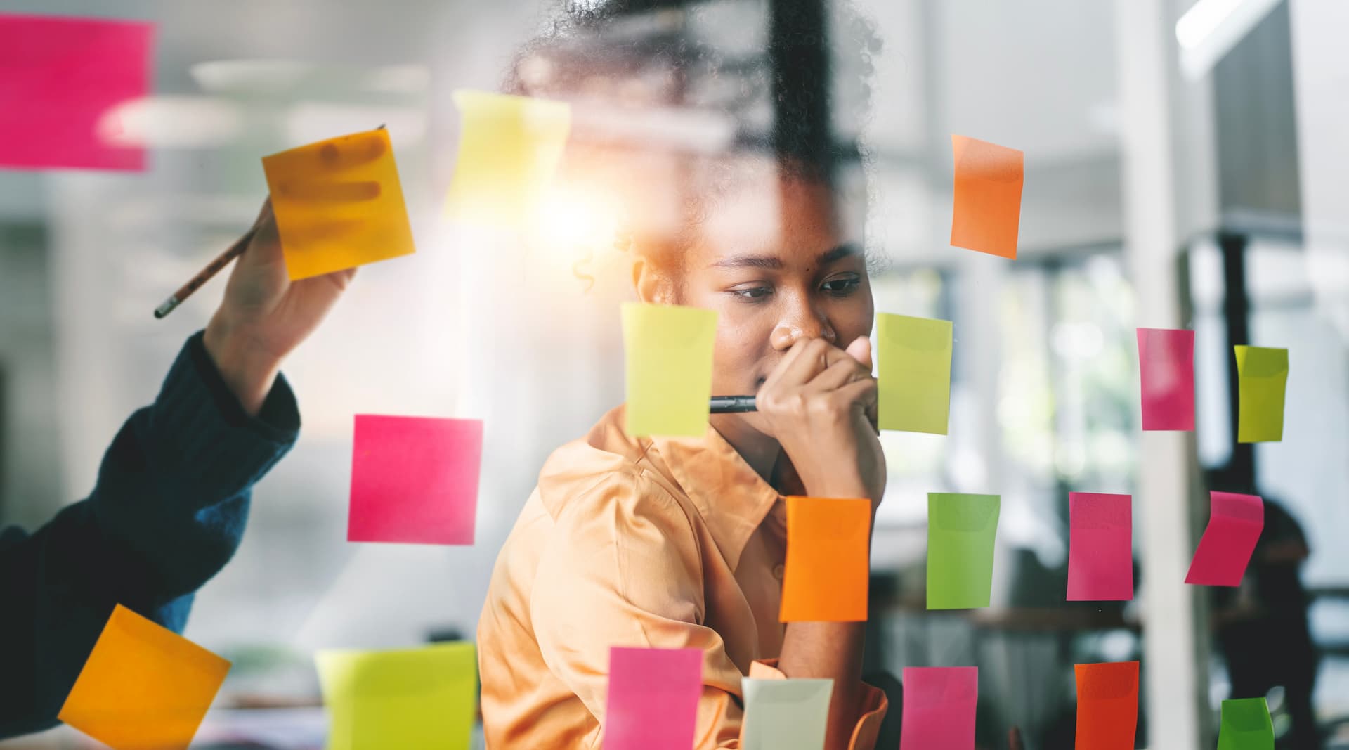 Workshop-Prozess - Person vor Glaswand mit bunten Post-its